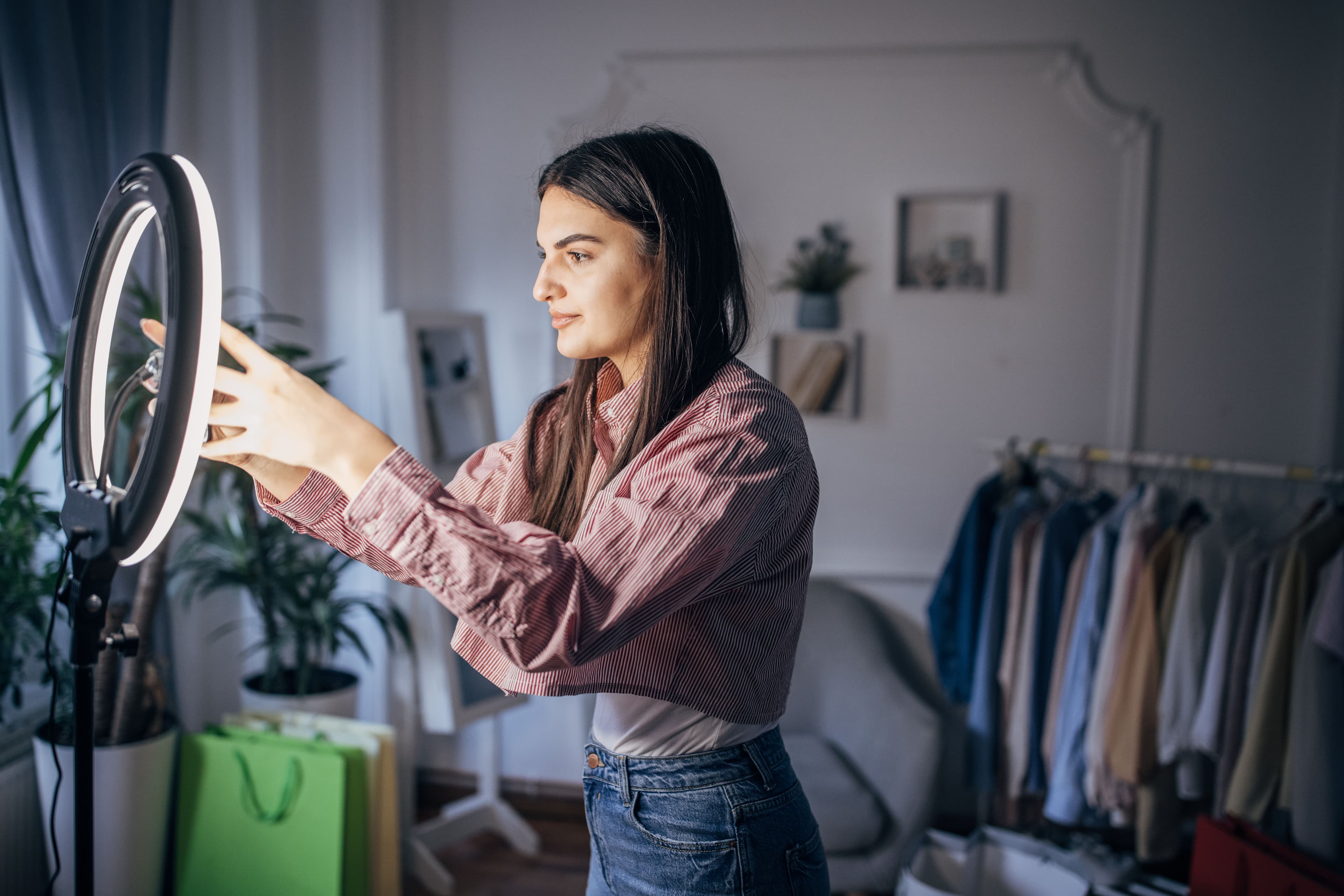 Ung kvinde sætter sin mobil fast i en ring light