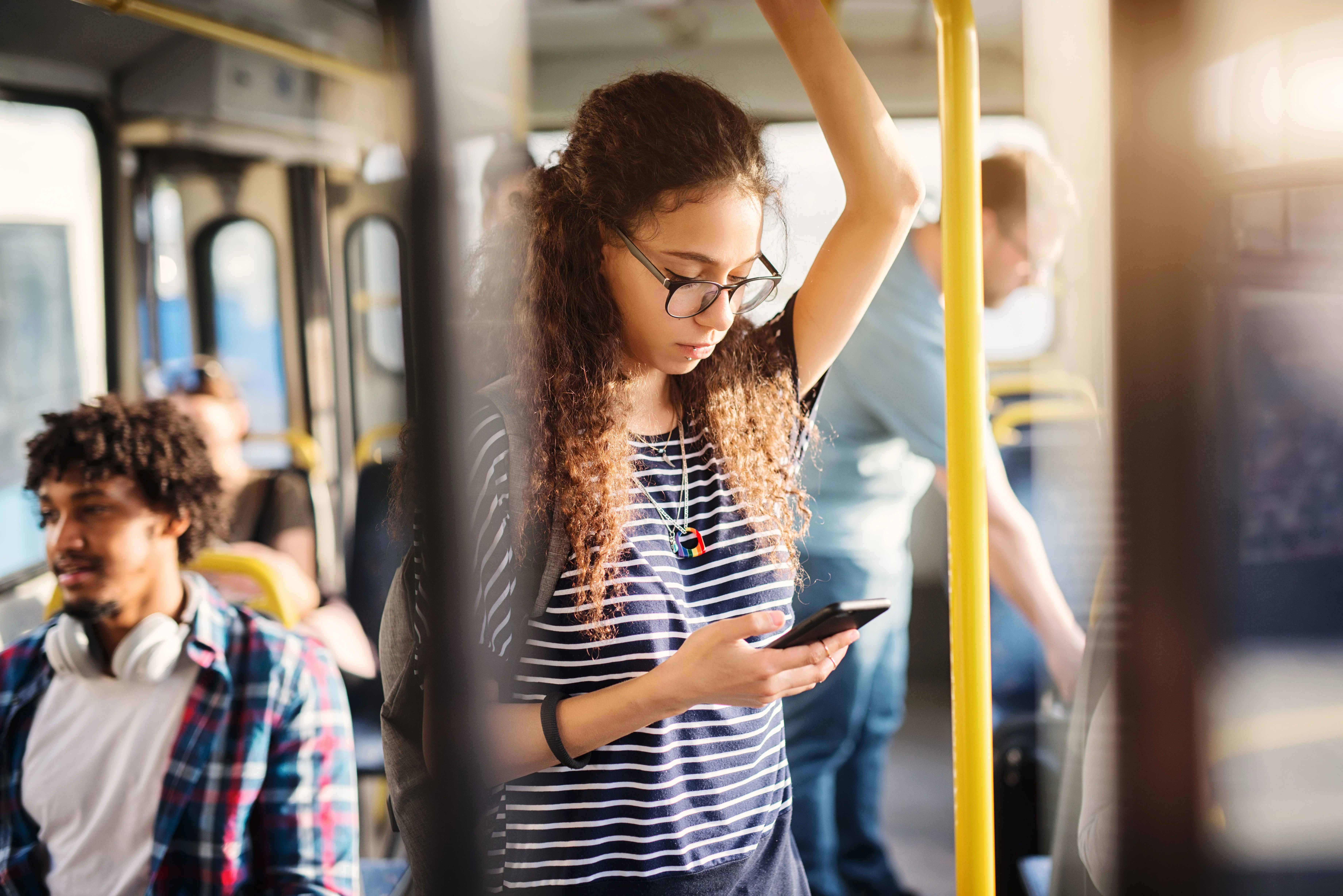 Piger står i bussen og kigger bekymret på sin smartphone.