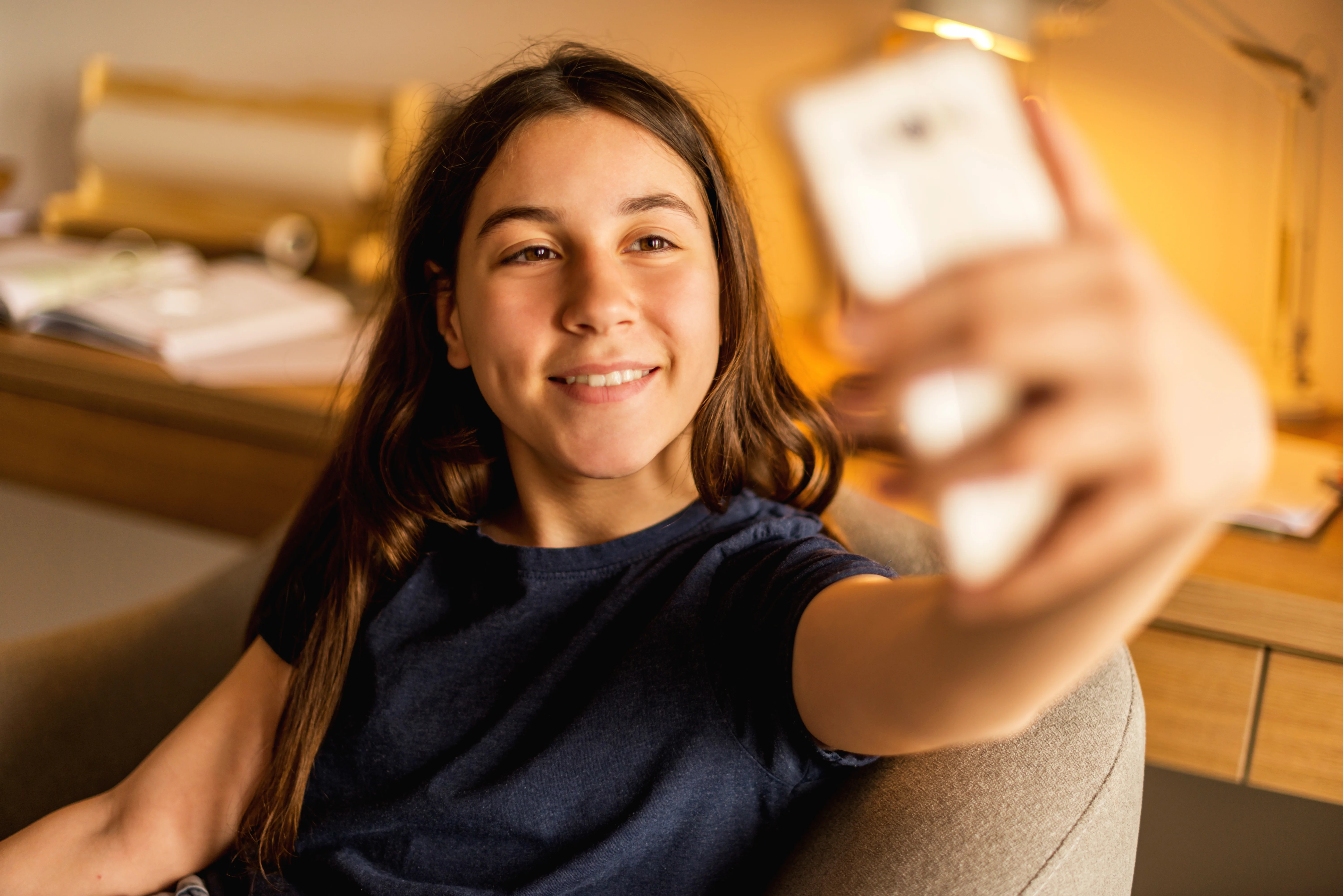Barn smiler og tager selfie med smartphone